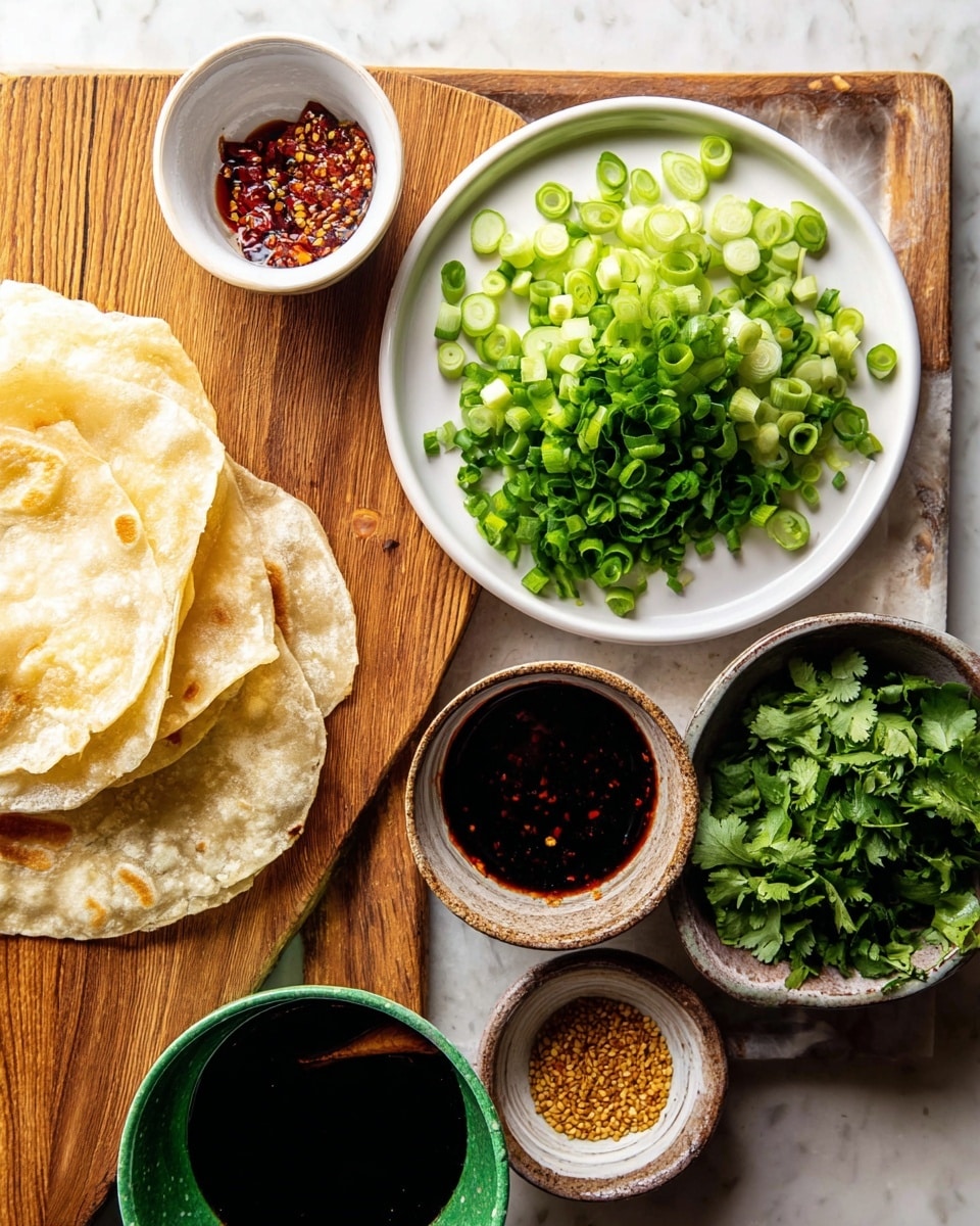 A white bowl with soft, golden flatbread folded inside is on the left side of the image, resting on a white marbled surface. In the center, a wooden board holds a white round plate full of bright green sliced scallions at the top, with tiny green chopped cucumbers scattered to the right. Below the plate, three small bowls are arranged: one with dark soy sauce, one with red chili flakes soaked in oil, and one with a golden sesame seed sauce. At the bottom right, a green ceramic bowl is filled with loose, dark green cilantro leaves. Photo taken with an iphone --ar 4:5 --v 7