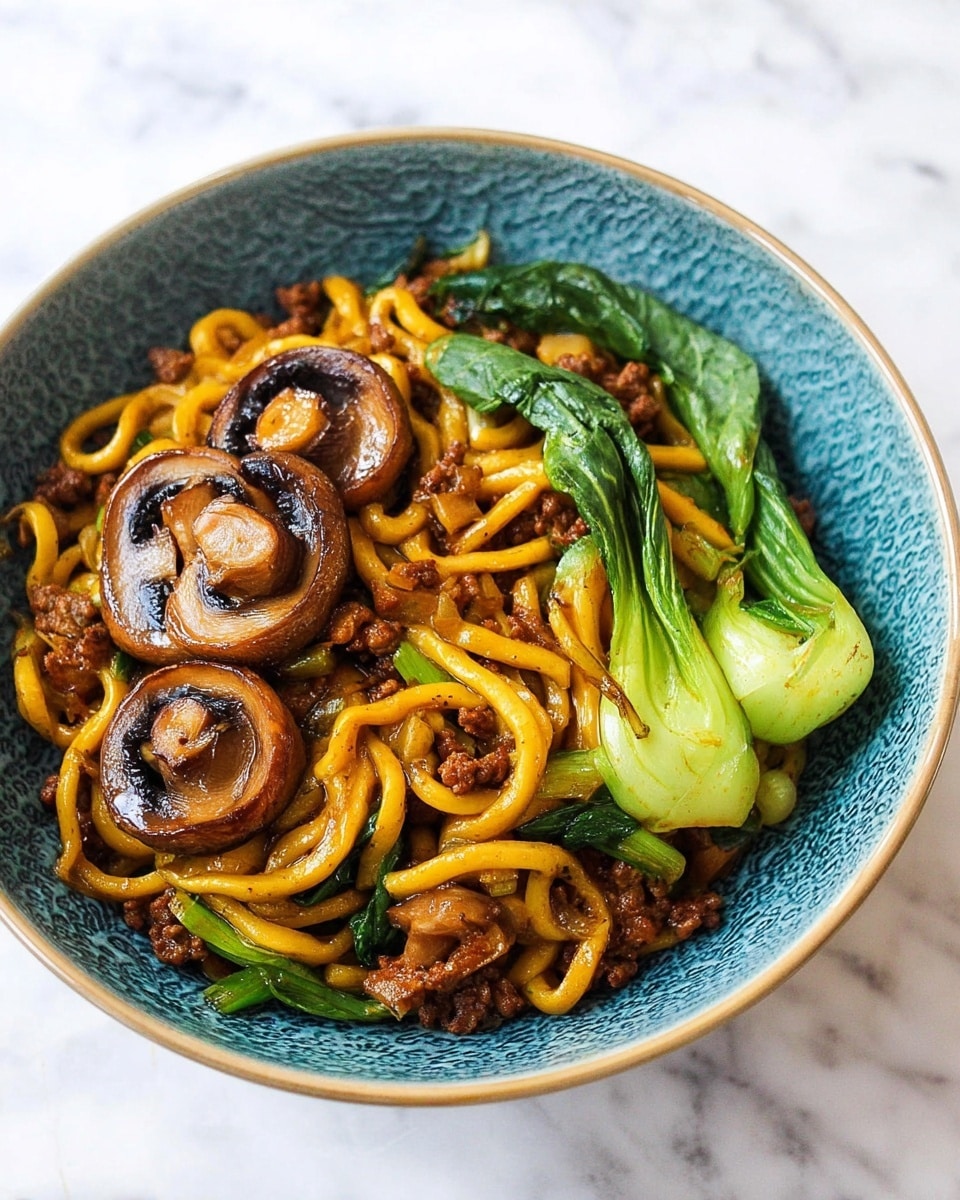 A bowl filled with thick, golden-yellow noodles tangled with small, dark brown meat pieces, bright green bok choy leaves on the side, and three thick slices of glossy, cooked brown mushrooms placed on top, all served in a textured blue bowl set on a white marbled surface. Photo taken with an iphone --ar 4:5 --v 7