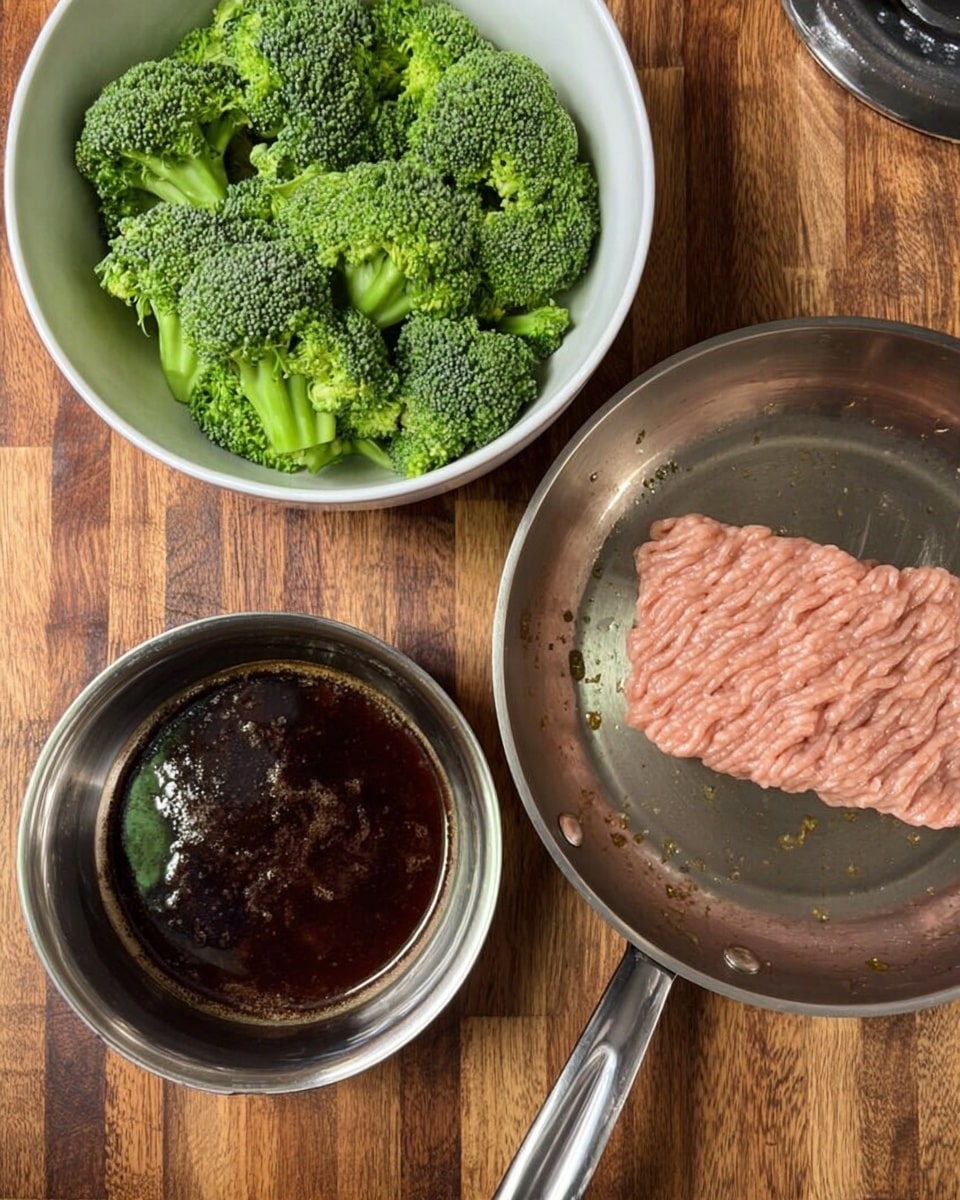 The image shows a cooking scene on a wooden surface with three main items: a white bowl filled with bright green broccoli pieces with a rough texture, placed at the top left; a shiny steel bowl containing a dark brown liquid with a smooth surface and some bubbles, set below the broccoli bowl on the left side; and a silver frying pan on the right side, holding a single flat layer of light pink raw ground meat with a smooth and slightly wavy texture, sitting on a stovetop. The overall scene is bright and clear, with the wood grain background visible under the items. photo taken with an iphone --ar 4:5 --v 7
