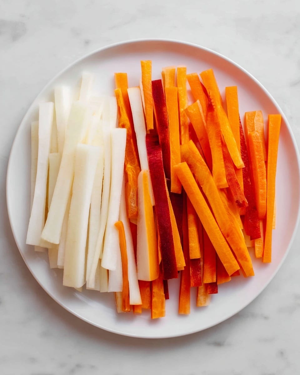 A white plate holds a neat row of two types of thin vegetable sticks arranged side by side on a white marbled surface. On the left, there are white, smooth, slightly translucent radish sticks stacked in a tidy pile. Next to them on the right, there are bright orange carrot sticks mixed with a few darker orange and reddish carrot sticks, also stacked neatly. The two types of sticks create a clear contrast in color and texture, arranged in straight lines across the plate. Photo taken with an iphone --ar 4:5 --v 7