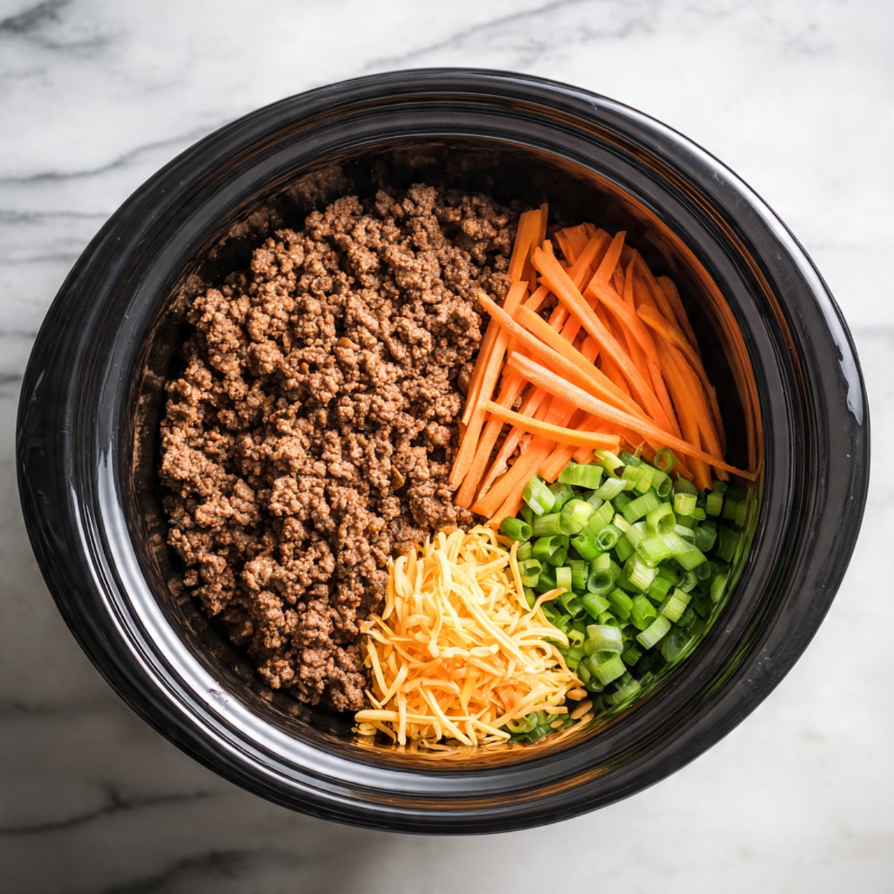 Inside a black slow cooker, three main layers sit side by side. On the left, there is a layer of cooked ground meat with a crumbly texture and a brownish color. To the right of the meat, there are thin carrot sticks and small bright green pieces of chopped green onions. On the far right, a small pile of shredded light orange cheese completes the mix. The inner surface of the slow cooker is shiny black, and the whole scene is set on a white marbled textured surface. Photo taken with an iphone --ar 4:5 --v 7