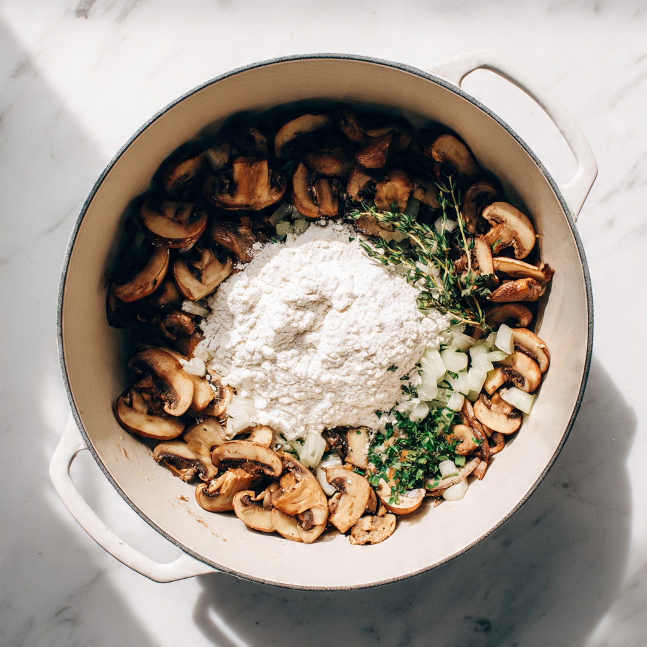 The image shows a white cooking pot filled with sautéed sliced mushrooms and small diced onions, golden brown with a slightly shiny texture, mixed with fresh green herb pieces. In the center, a mound of white flour rests on top of the mushrooms and onions, waiting to be stirred in. The pot is placed on a white marbled surface, with soft light casting gentle shadows and highlights. Photo taken with an iphone --ar 4:5 --v 7