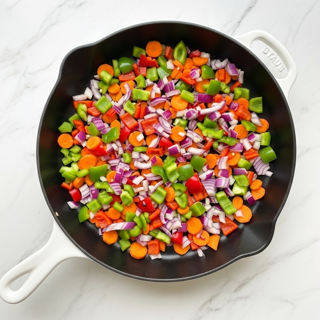A black cast iron pan with a white handle sits on a white marbled surface, filled with chopped vegetables. The top layer includes small pieces of green bell peppers, bright red bell peppers, and orange carrots, all mixed together with chopped red onions that add a purplish color. The vegetables are spread evenly across the pan, showing a fresh and colorful mix with crunchy textures. photo taken with an iphone --ar 4:5 --v 7