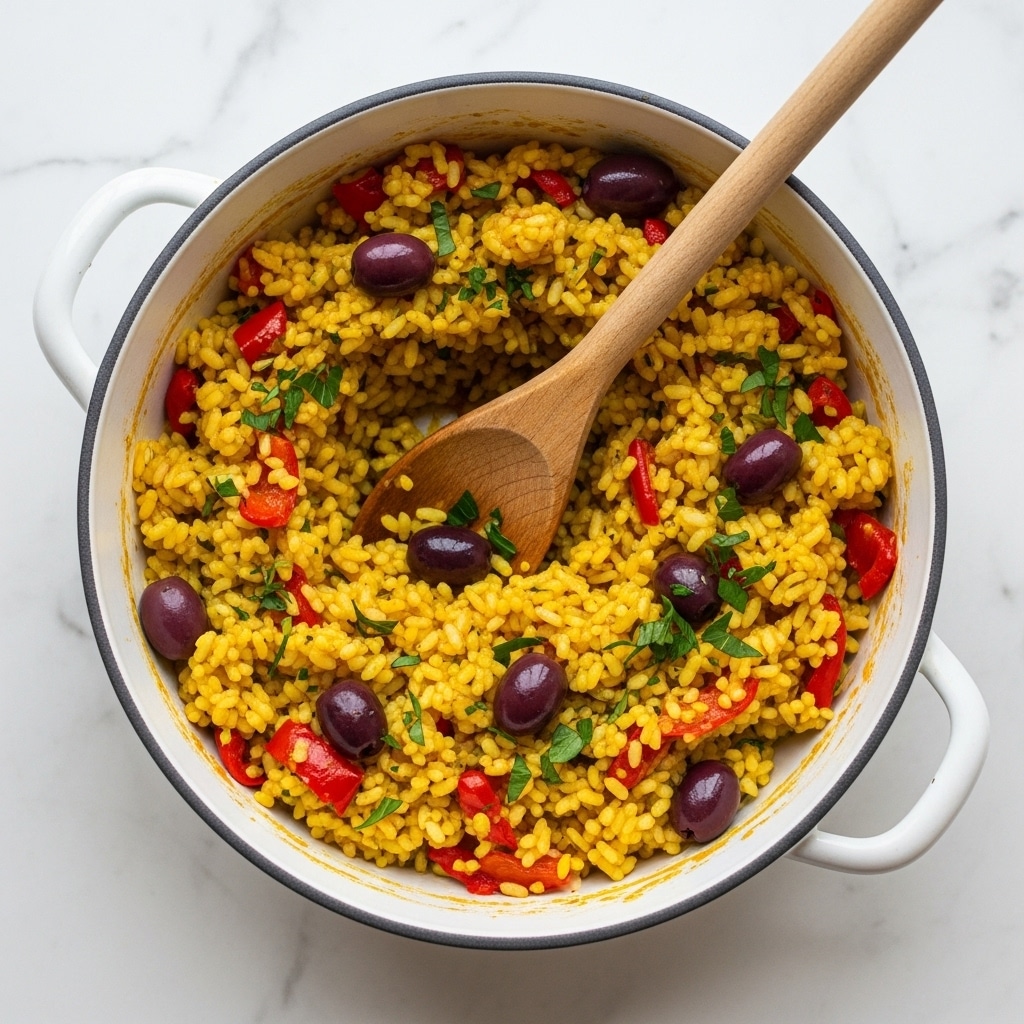A white enamel pot filled with a yellow rice dish mixed with red pepper pieces and dark purple olives scattered throughout. The rice looks fluffy with small bits of green herbs sprinkled both inside and mostly on top. A wooden spoon stands inside the pot, leaning on the side, partially covered with the rice mixture. The pot sits on a white marbled surface, enhancing the natural and fresh look of the dish. photo taken with an iphone --ar 4:5 --v 7