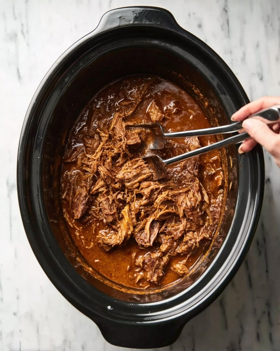 A black slow cooker filled with shredded pieces of cooked meat in a thick brown sauce, with some chunks floating on top. Two metal forks rest inside the cooker, one with a woman's hand holding it, mixing or picking the meat. The slow cooker sits on a white marbled surface, showing some sauce stains on the sides inside the cooker. photo taken with an iphone --ar 4:5 --v 7