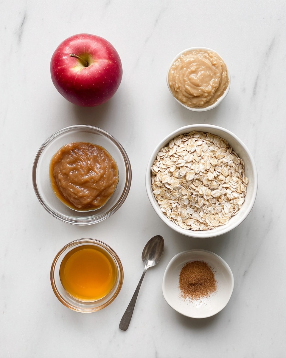 A clean layout on a white marbled surface shows five main ingredients neatly arranged: a red apple on the top left, a clear glass bowl with smooth brown almond butter to the top right, a white bowl filled with light beige rolled oats at the center, a small white bowl with golden honey at the bottom left, a clear glass bowl with light beige applesauce at the bottom right, and a small silver spoon with brown cinnamon powder near the center right. The items are spaced out evenly, creating a simple and fresh look photo taken with an iphone --ar 4:5 --v 7