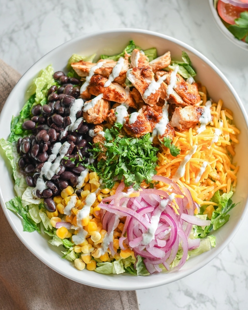 The dish is served in a white bowl on a white marbled surface, showing four main layers arranged in sections. At the bottom, there is a bed of shredded green lettuce, covering most of the bowl. On one side, there are black beans, deep black and glossy with a slight sauce. Next to the beans is a heap of bright yellow corn mixed with small bits of orange shredded cheddar cheese and fresh green cilantro sprinkled on top. Opposite the beans, there are pieces of cooked chicken with a light brown sauce and drizzles of white creamy dressing, resting beside thin rings of red onion. The whole bowl looks fresh with colorful textures and contrasts, photo taken with an iphone --ar 4:5 --v 7