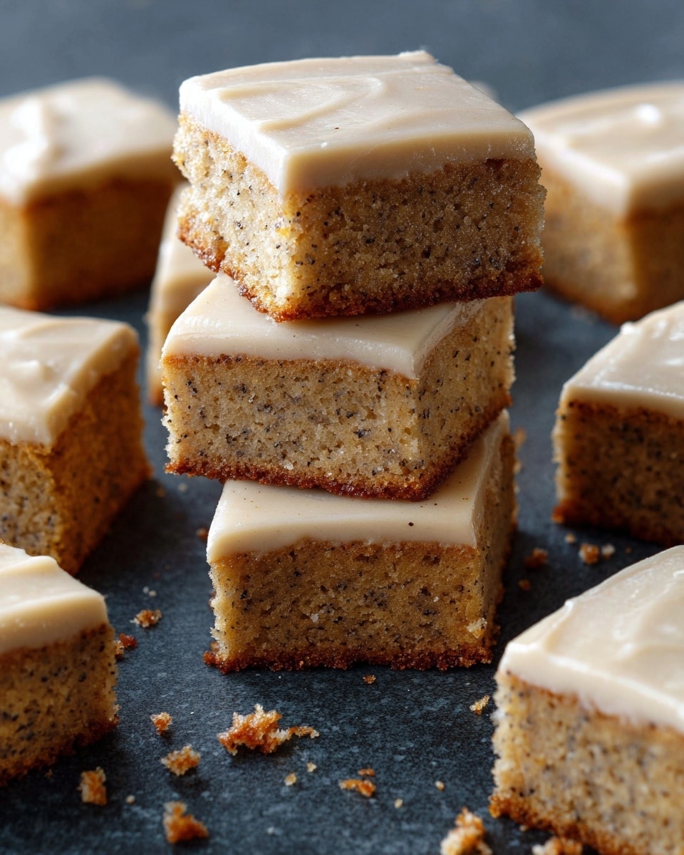 The image shows several square pieces of light brown cake with tiny dark specks evenly spread inside. Each piece has one smooth layer of light beige icing on top. In the center, three pieces are stacked on top of each other, showing the thick, moist texture of the cake and the even layer of icing on each piece. The squares are placed directly on a dark surface, and some crumbs are scattered around, giving a fresh, homemade feel. Photo taken with an iphone --ar 4:5 --v 7