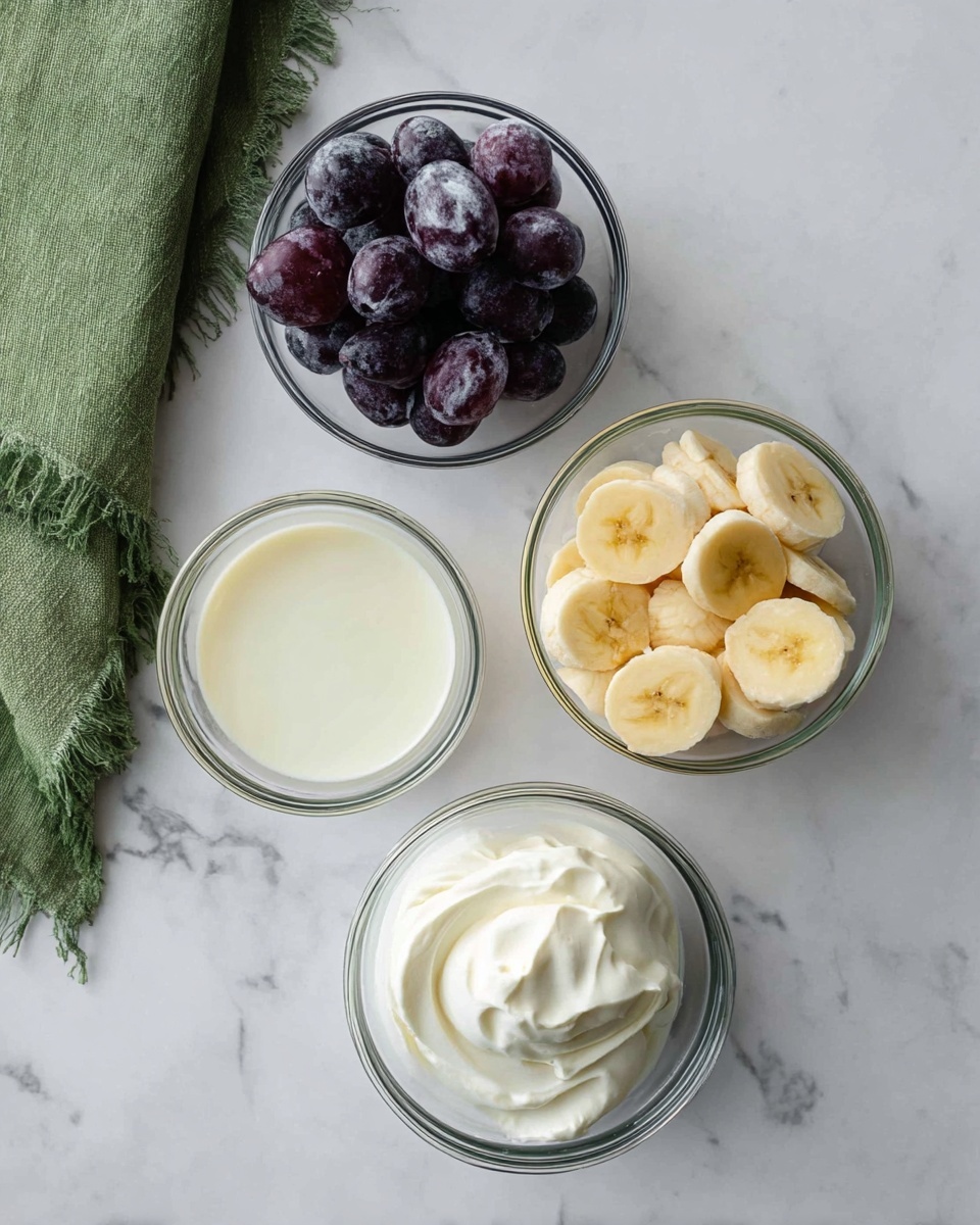 The image shows four glass bowls arranged on a white marbled surface. The top left bowl is filled with dark purple grapes that have a slightly frosted look. The top right bowl contains neatly sliced banana pieces, pale yellow with soft textures. Below these, a small bowl of pale cream or milk is placed slightly left of center. At the bottom of the image, another bowl holds a thick, white creamy substance with a smooth texture. A green cloth with fringed edges is partially visible on the left side. Photo taken with an iphone --ar 4:5 --v 7