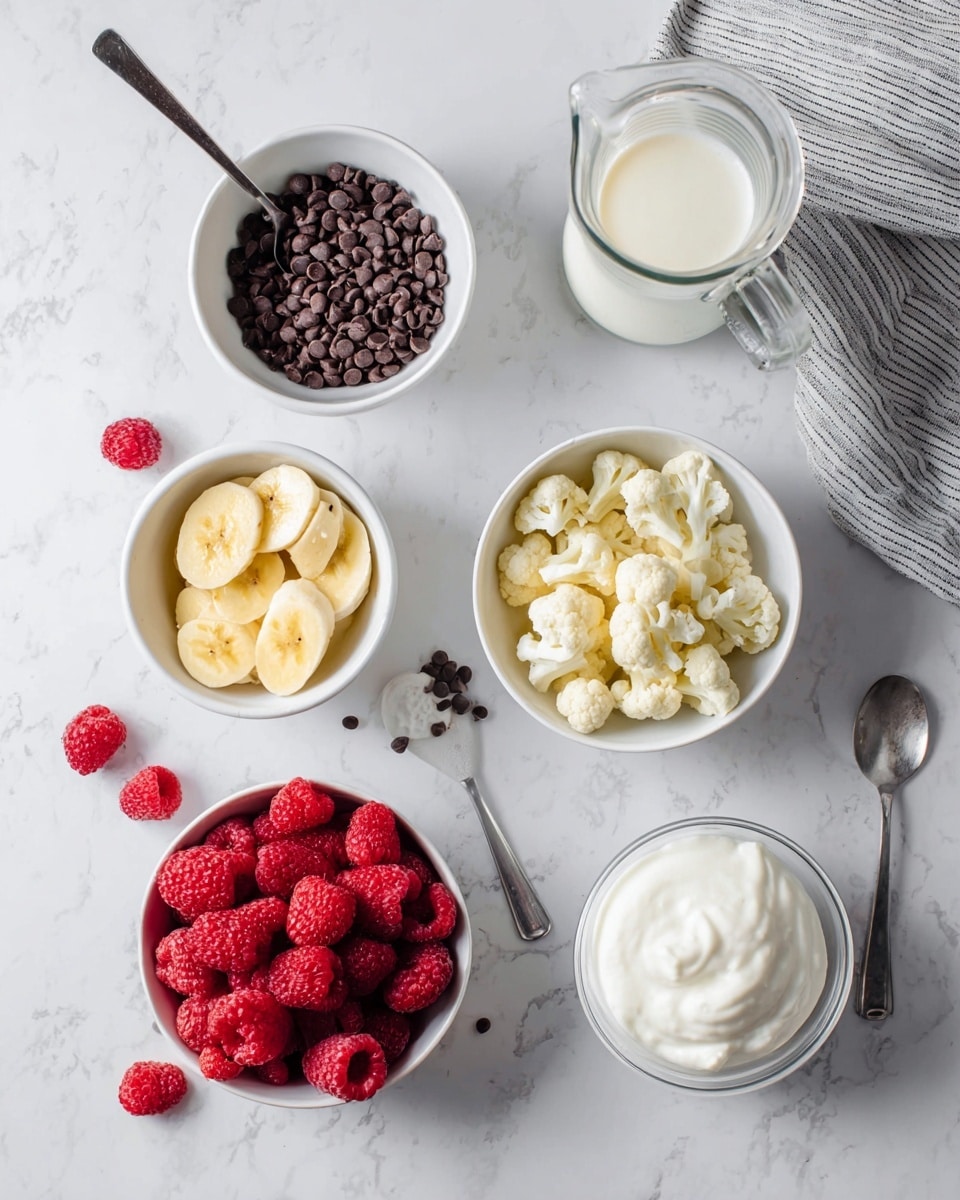 The image shows six white bowls and a small glass jug on a white marbled surface. The top left bowl contains small dark brown chocolate chips with a spoon inside. To the right of it is a clear glass jug filled with white milk, next to a gray and white striped cloth. Below the chocolate chips is a bowl filled with bright red frozen raspberries, with a few loose raspberries scattered around. To the right is a bowl of small, off-white cauliflower pieces. In the bottom left corner, there is a bowl of sliced yellow banana pieces, with a few slices placed outside the bowl. At the bottom right, there is a bowl of thick white yogurt with a small spoon next to it. photo taken with an iphone --ar 4:5 --v 7
