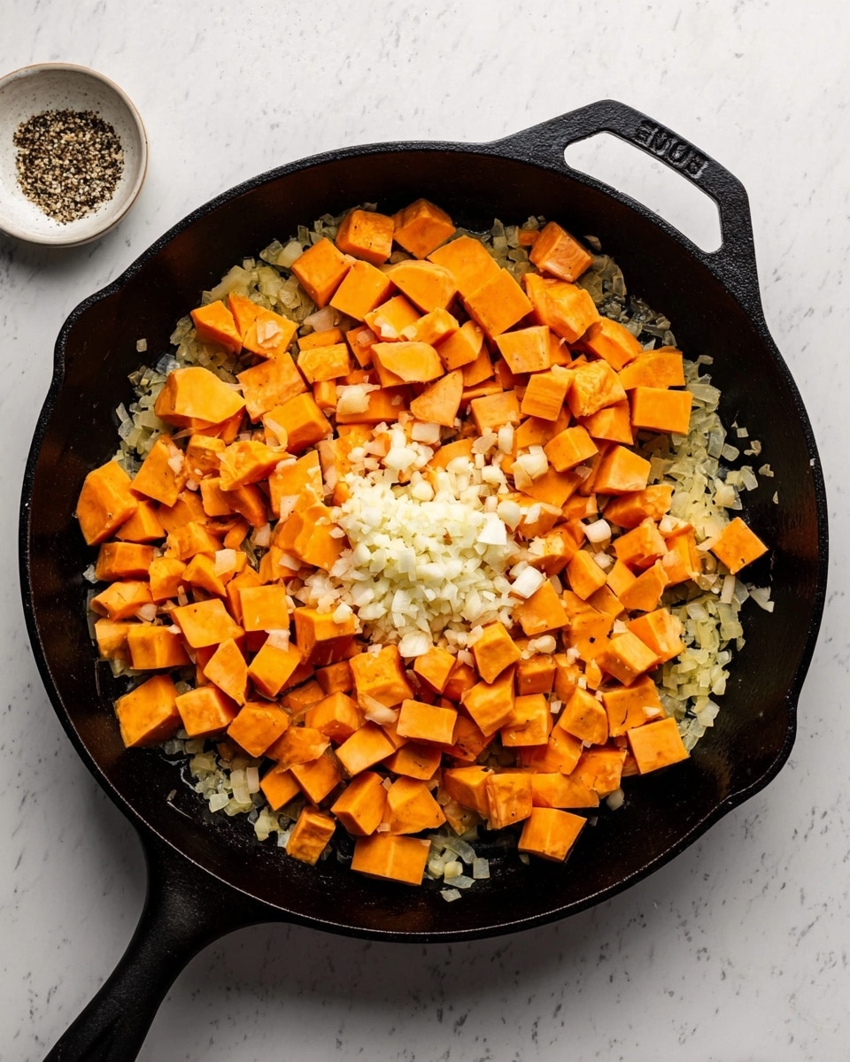 A black cast iron pan is filled with three layers of food. The bottom layer is bits of cooked onion, light yellow with bits of green. On top of that are many small orange cubes of sweet potato, spread evenly across the pan. In the center, there is a small pile of finely chopped white garlic. The pan is placed on a white marbled surface with a small white bowl of coarse salt and pepper nearby. Photo taken with an iphone --ar 4:5 --v 7