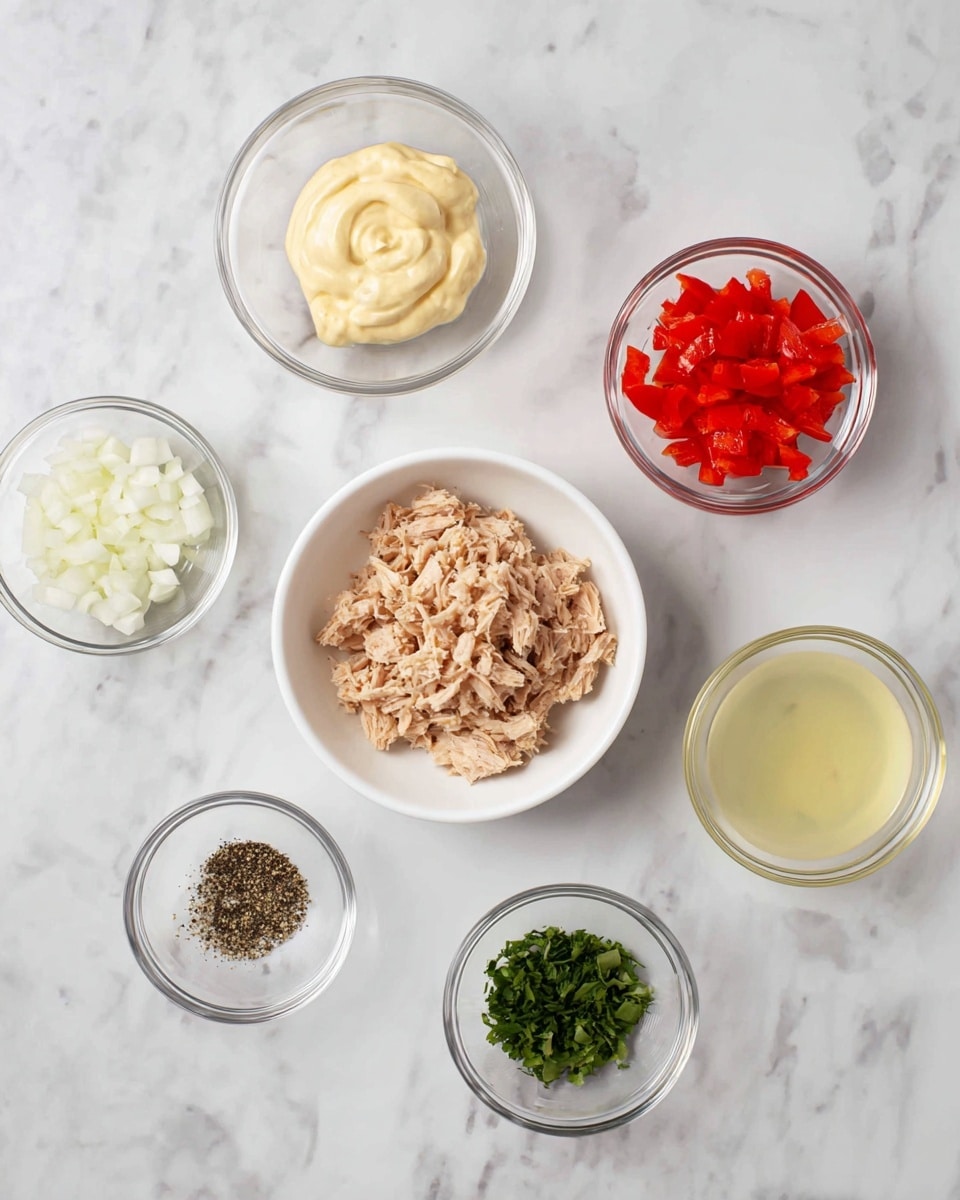 There are six small clear glass bowls and one white bowl arranged on a white marbled surface. In the center is the white bowl filled with light brown shredded tuna. Above it to the left is a bowl with creamy pale yellow mayo. To the right is a bowl with finely chopped white onion. At the top center is a bowl with diced bright red bell pepper. Below to the left is a bowl with ground black pepper. Below to the right is a bowl with chopped green herbs. At the bottom center is a bowl with clear lemon juice. All bowls are spread out evenly in a neat arrangement. Photo taken with an iphone --ar 4:5 --v 7
