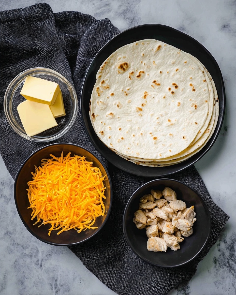 The image shows four black bowls arranged on a dark cloth over a white marbled surface. The largest bowl at the top holds a stack of five white tortillas with light brown spots, neatly layered. To the right, a medium bowl contains small, light brown pieces of cooked chicken. To the left, another medium bowl is filled with bright orange shredded cheese, overflowing slightly. Above the cheese bowl is a small glass bowl holding two square pieces of yellow butter. The arrangement is clear and simple, with each ingredient separated and ready to use photo taken with an iphone --ar 4:5 --v 7