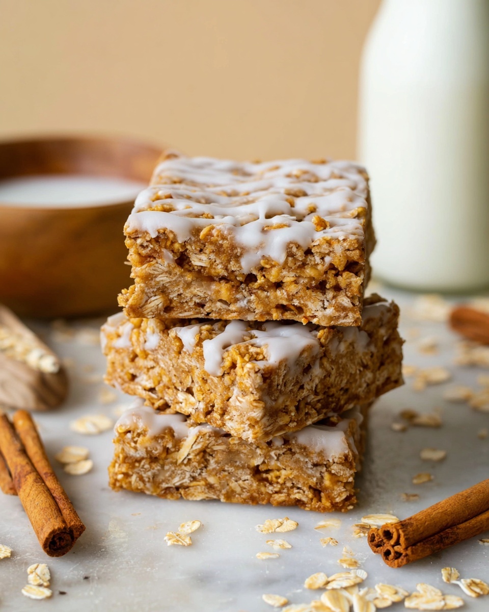 A stack of three square oat bars with a rough texture, showing visible oats and a light drizzle of white icing on top, sits centered on a white marbled surface. The bars are golden-brown in color with tiny air pockets and flaky oat pieces throughout. Surrounding the stack are loose oat flakes and two cinnamon sticks on the right side. In the background, there is a white bottle and a small wooden bowl filled with milk, slightly blurred to keep focus on the oat bars. photo taken with an iphone --ar 4:5 --v 7