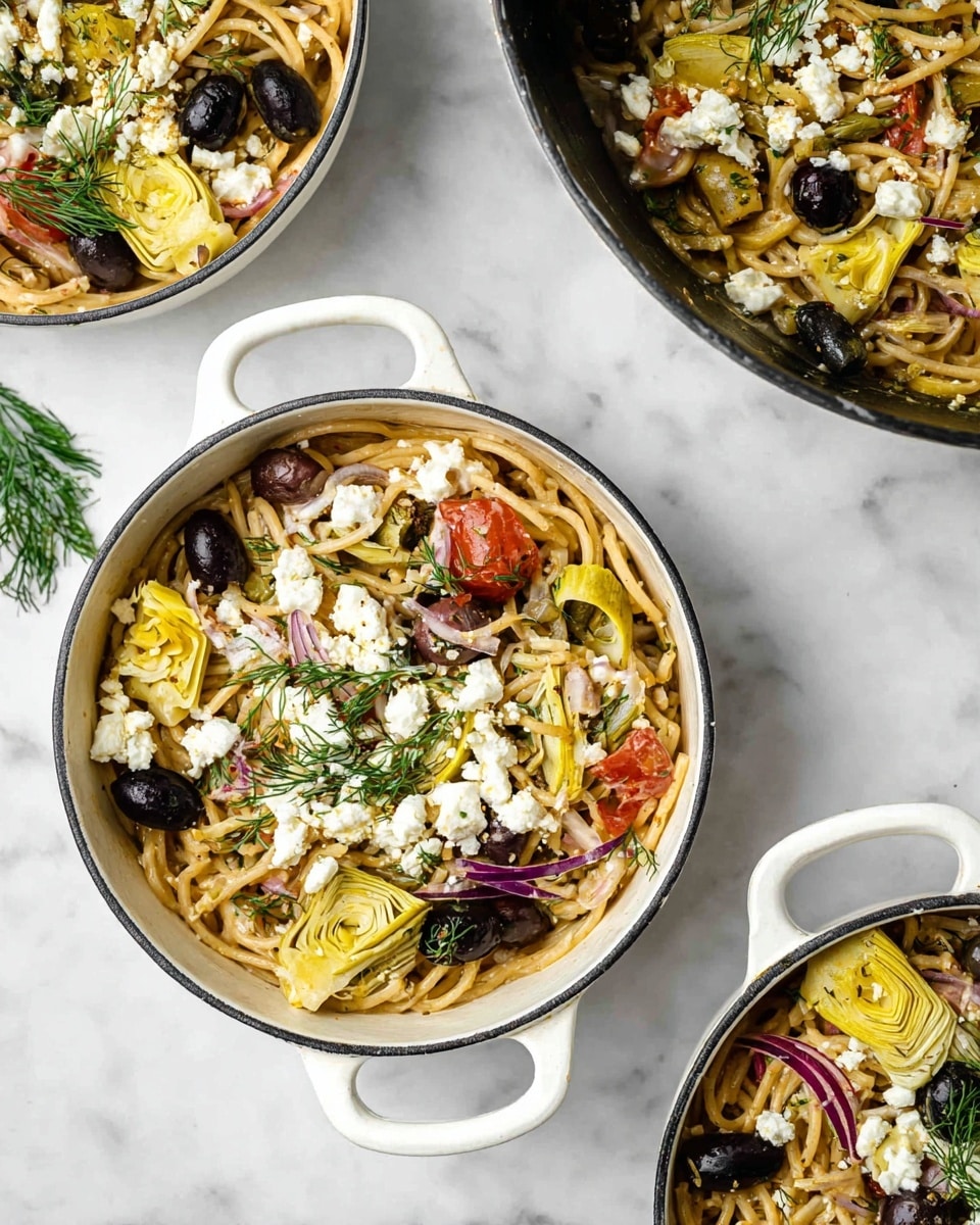 The image shows a close-up of bowls and a pan filled with a pasta dish on a white marbled surface. The dish has long, light brown pasta as the base layer, mixed with slices of yellow artichoke hearts and black and green olives scattered throughout. There are small bits of red tomatoes and thin slices of purple onion adding color on top of the pasta. White crumbled cheese is sprinkled all over, providing a contrast to the darker ingredients. Fresh green dill sprigs are placed on top as a final garnish. The bowls are white with handles, and the pan is round and black on the outside with the pasta filling nearly to the rim. Photo taken with an iphone --ar 4:5 --v 7