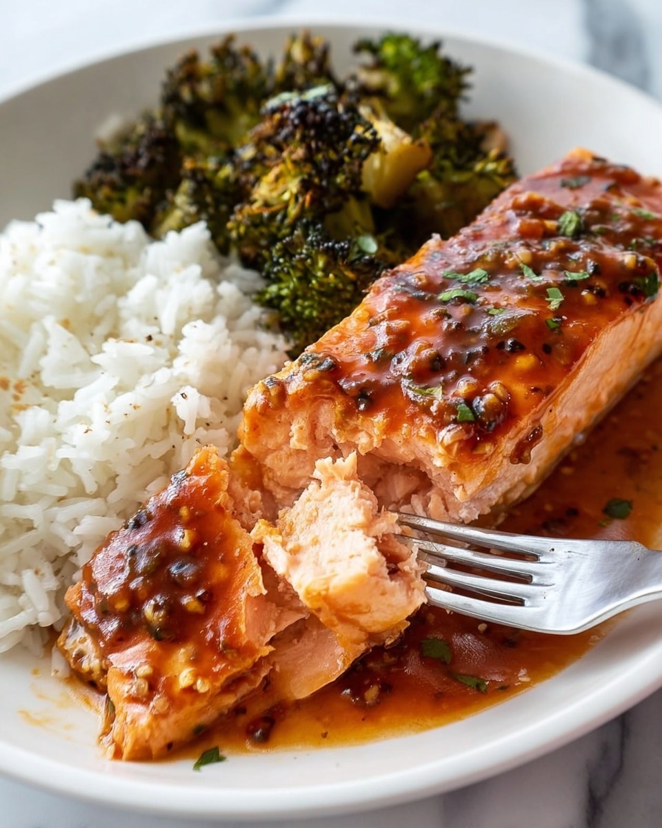 A white plate with three main parts: on the left side, there is a small pile of white rice with soft, individual grains; beside it, some dark green roasted broccoli pieces with slightly charred edges; and on the right, a thick piece of cooked salmon with a glossy reddish-brown sauce covering the top and part of the side. The salmon is being gently pierced by a silver fork from the right, showing its light pink, flaky inside layers under the sauce. The sauce pools on the plate underneath the salmon, showing a mix of smooth and chunky textures with visible bits. The background is a white marbled texture. photo taken with an iphone --ar 4:5 --v 7