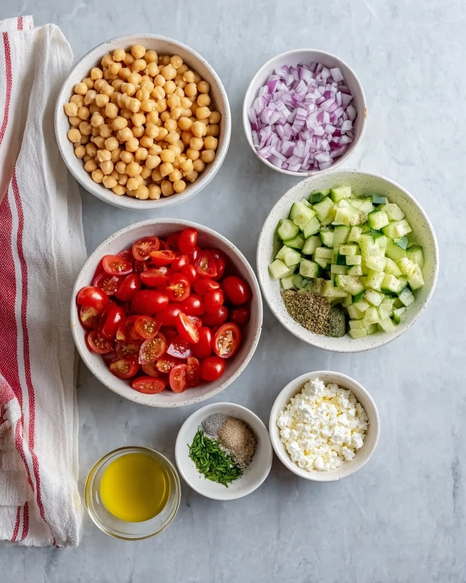 The image shows six white bowls arranged on a white marbled surface. The largest bowl at the bottom center contains three layers of vegetables: bright red cherry tomatoes on the left, light green cucumber pieces on the right, and finely chopped purple onions on the top. Above it to the left is a medium bowl filled with round beige chickpeas. To the right of the chickpeas is a smaller bowl with a mix of herbs and spices, including green chopped herbs, a white powder, black pepper, and a yellowish powder, separated into sections. Below that is another tiny white bowl with soft white cheese crumbles. To the right of the cheese is a small cup with clear yellow olive oil. Next to it is another tiny cup with clear lemon juice. A white cloth with red stripes is folded and placed on the left side. photo taken with an iphone --ar 4:5 --v 7