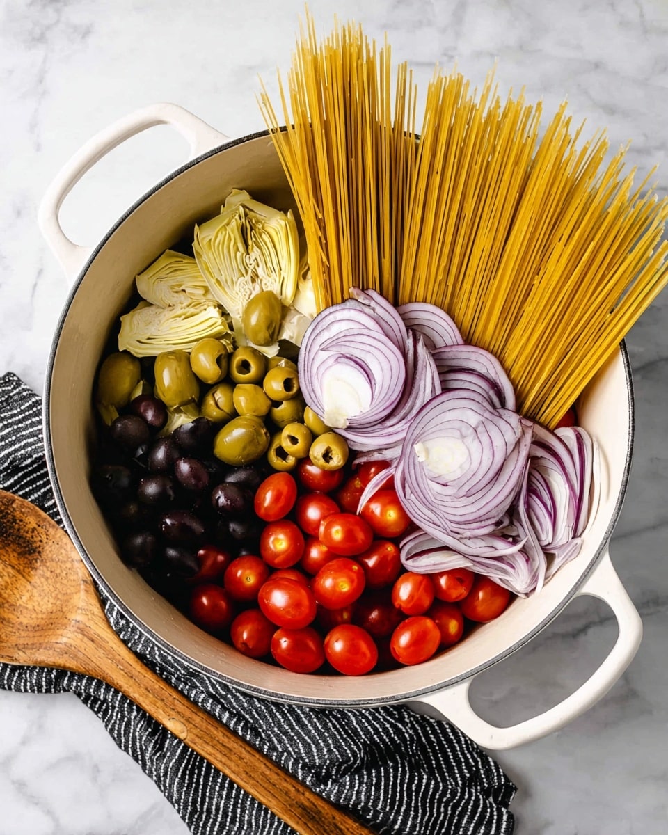 A white pot filled with several raw ingredients arranged in layers. On the right side, there are thin slices of purple onion with a curved shape. Next to the onions are long, dry spaghetti strands standing upright and leaning slightly inward. Below the pasta, bright red cherry tomatoes form a cluster. To the left of the tomatoes, pale yellow artichoke hearts add a soft texture. Black olives are grouped in the upper left area, with green olives positioned near them. The pot sits on a white marbled surface with a black and white striped cloth and a wooden spoon placed nearby. Photo taken with an iphone --ar 4:5 --v 7