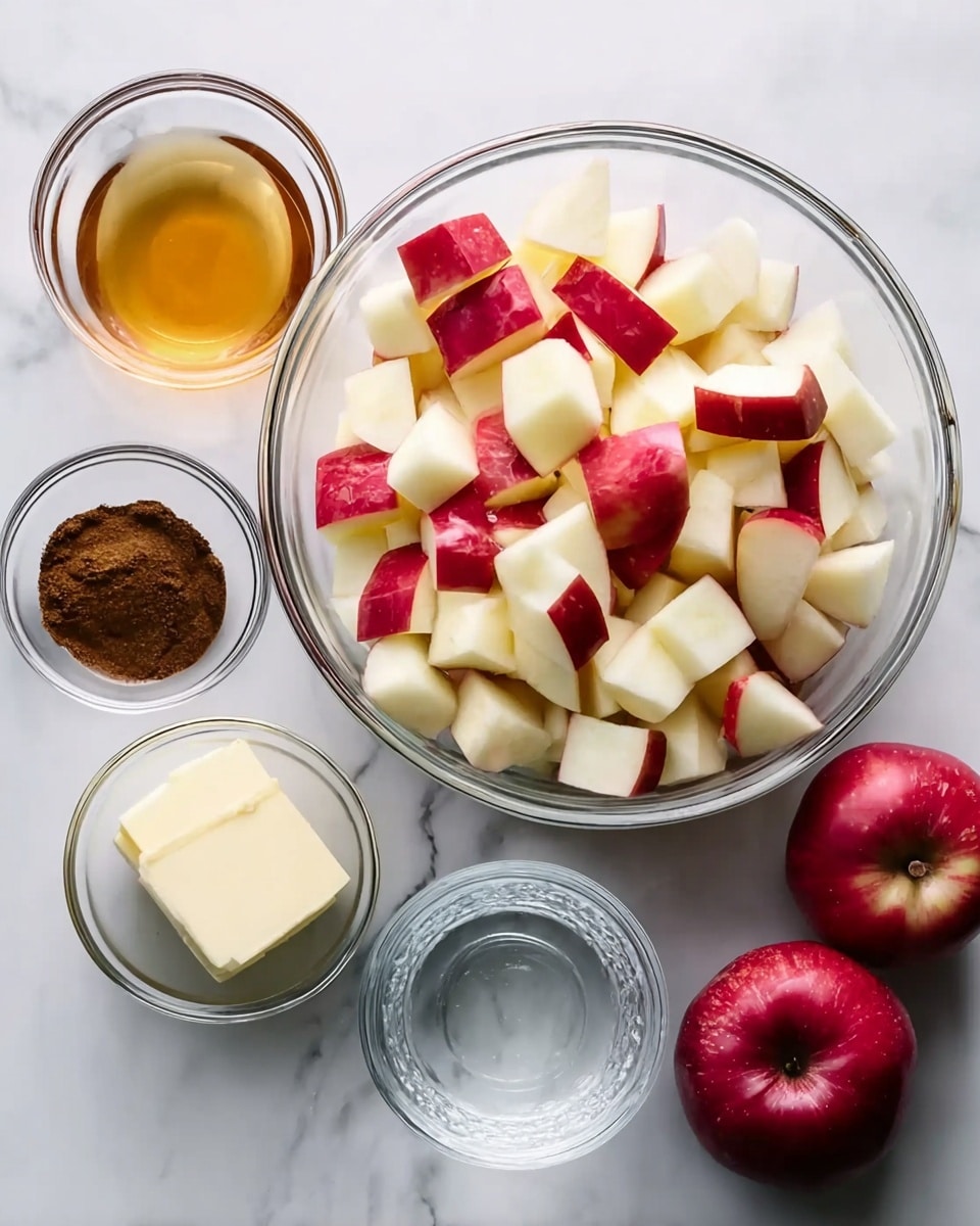 A clear glass bowl in the center is filled with many apple pieces that have red skin and white flesh. Around this big bowl are four small clear glass bowls: the top left bowl contains a golden-brown liquid, the bottom left has a dark brown powder, the bottom middle has a small block of off-white butter, and the right bowl has clear water. To the right side, there are two whole red apples. All items are placed on a white marbled surface. photo taken with an iphone --ar 4:5 --v 7
