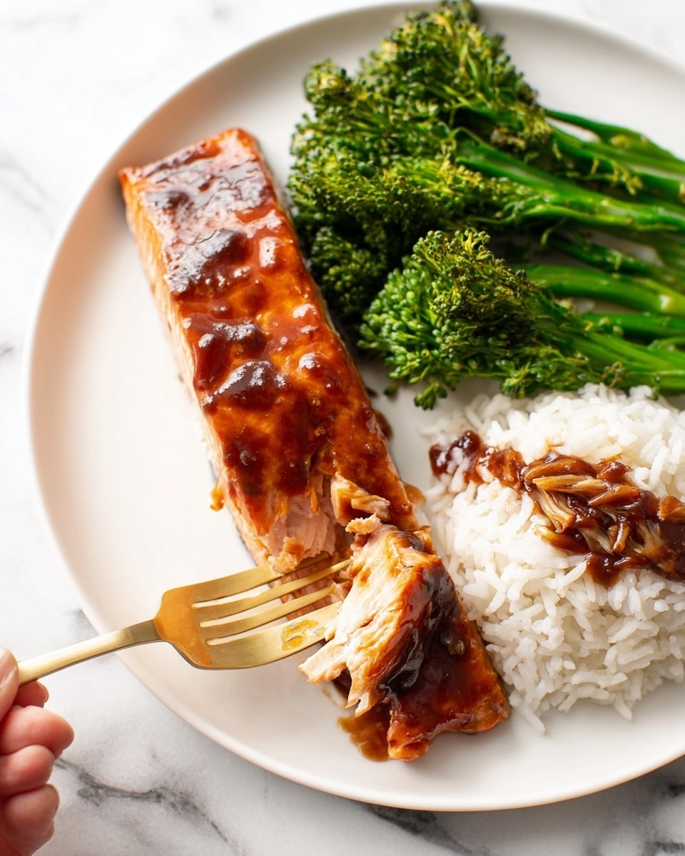 A cooked salmon fillet with a shiny, sticky brown glaze sits on the left side of a white plate, with a woman's hand holding a gold fork gently pulling a piece from the bottom left corner. On the upper middle part of the plate, there are bright green broccolini stalks with a textured surface. To the right of the broccolini, a mound of white rice is topped with a drizzle of dark brown sauce that pools slightly at the edges. The plate rests on a white marbled surface. photo taken with an iphone --ar 4:5 --v 7