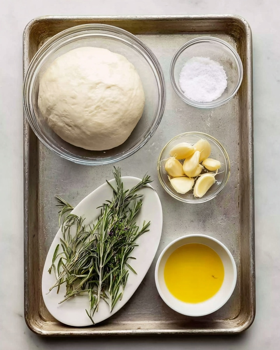 The image shows a metal tray with a round clear glass bowl filled with smooth white dough in the top left corner. To the right of the dough, there is a small clear bowl with white salt. Below the dough, a white oval plate holds green rosemary sprigs. Next to the rosemary, a small clear bowl contains several peeled light yellow garlic cloves. In the bottom right corner, a small white bowl is filled with golden yellow oil. The tray rests on a white marbled surface. photo taken with an iphone --ar 4:5 --v 7