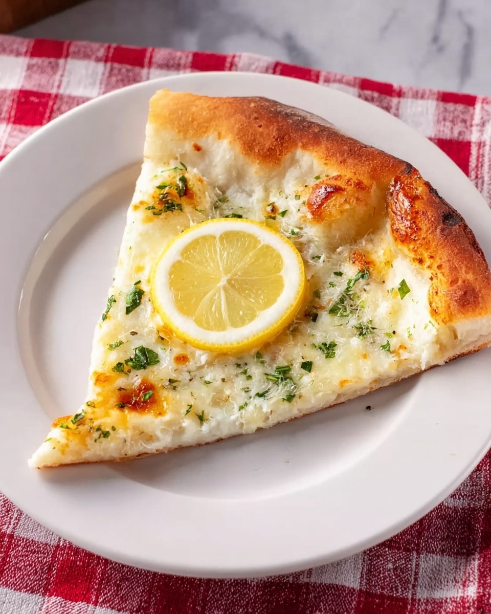 A single slice of pizza is placed in the center of a white plate. The pizza has a golden-brown crust that is thick and slightly puffed at the edges. The top layer displays melted white cheese with small green herb pieces scattered across it. In the middle of the slice sits a thin, bright yellow lemon slice with a translucent texture. The plate is set on a red and white checkered cloth on a white marbled surface. Photo taken with an iphone --ar 4:5 --v 7