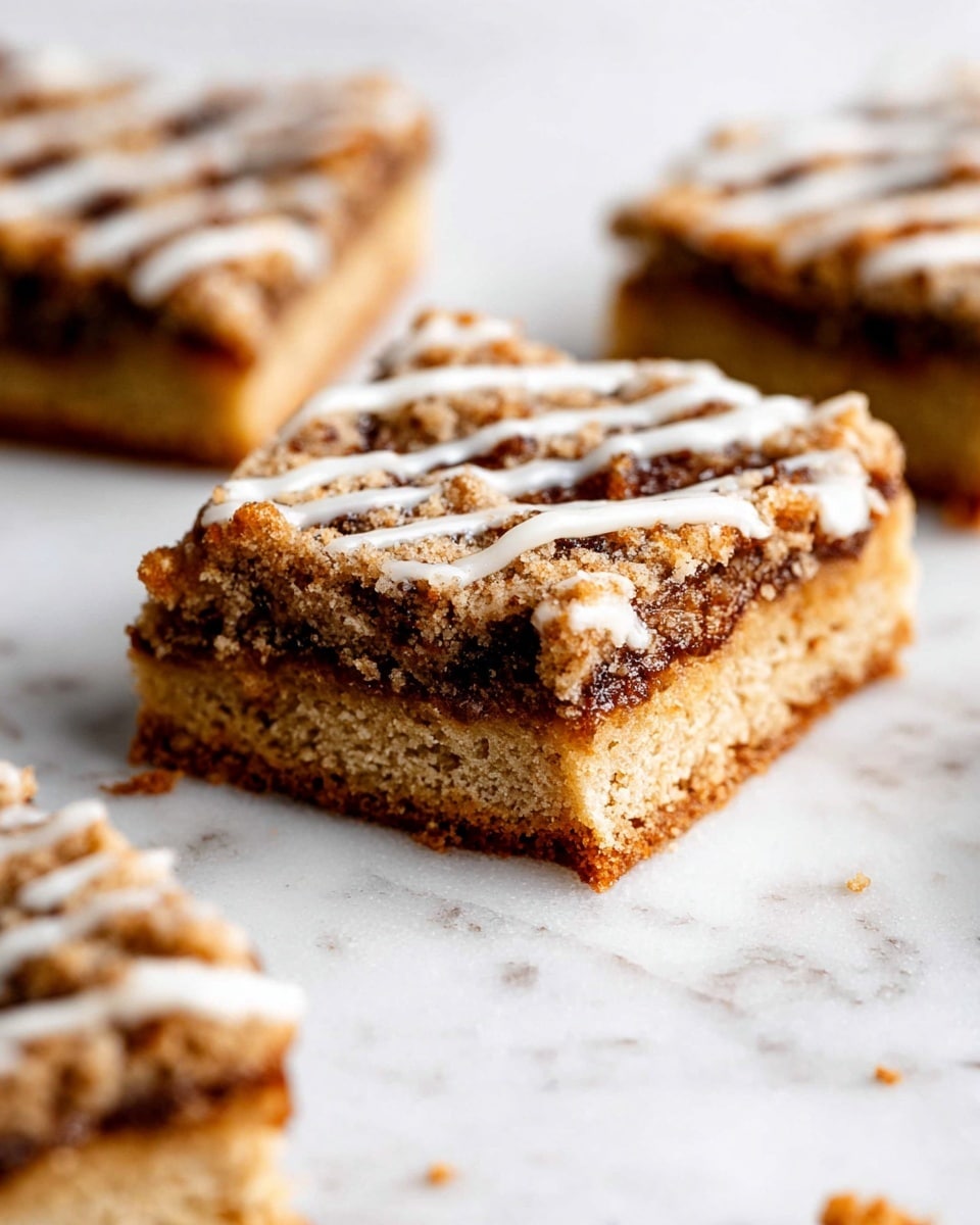 The image shows three square dessert bars on a white marbled surface, each with two main layers and a drizzle on top. The bottom layer is light golden brown and looks soft and crumbly, while the top layer is darker brown with a crumbly, slightly rough texture. White glaze is drizzled thinly in diagonal lines across the top crumb layer, adding contrast. The bars have slightly uneven edges, giving a homemade feel. Photo taken with an iphone --ar 4:5 --v 7