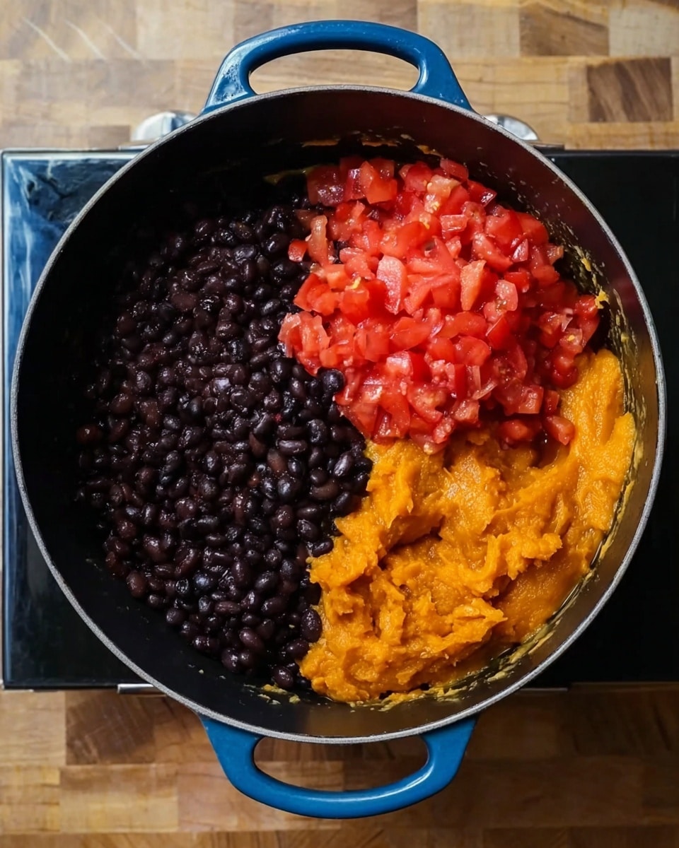 A large black cooking pot with blue handles contains three main layers of ingredients, each distinctly separate. On the left side, there is a dark, shiny layer of cooked black beans. To the top right, a bright red layer of diced tomatoes with a juicy texture sits beside the beans. Below the tomatoes, a smooth, thick orange layer resembling pureed squash or sweet potatoes fills the bottom right area. The pot rests on a black stove surface with a wooden textured table background, now imagined as a white marbled texture. Photo taken with an iphone --ar 4:5 --v 7
