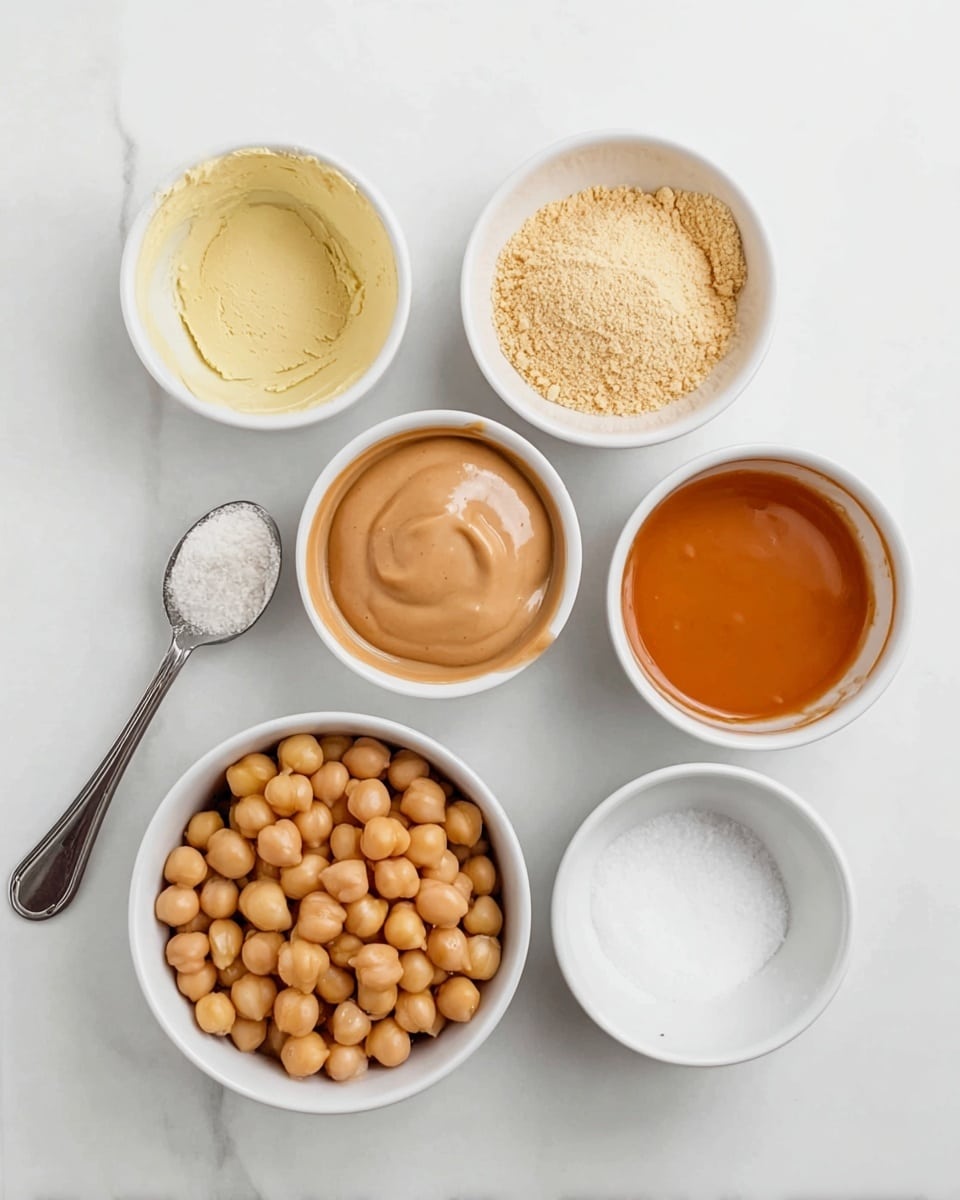 The image shows seven small bowls of different ingredients on a white marbled surface, arranged in a loose grid. In the top row, from left to right, there is a bowl with pale yellow powder, a bowl with a light brown liquid, and a bowl with a creamy tan thick sauce. Below them, starting on the left, a bowl filled with light brown chickpeas sits next to a small spoon with white powder on it. Next to the spoon, a small bowl contains white powder, and to the right, a bowl holds a smooth orange-brown liquid. All the bowls are white and the ingredients show a mix of smooth and textured appearances, with a neat and clean setup. Photo taken with an iphone --ar 4:5 --v 7