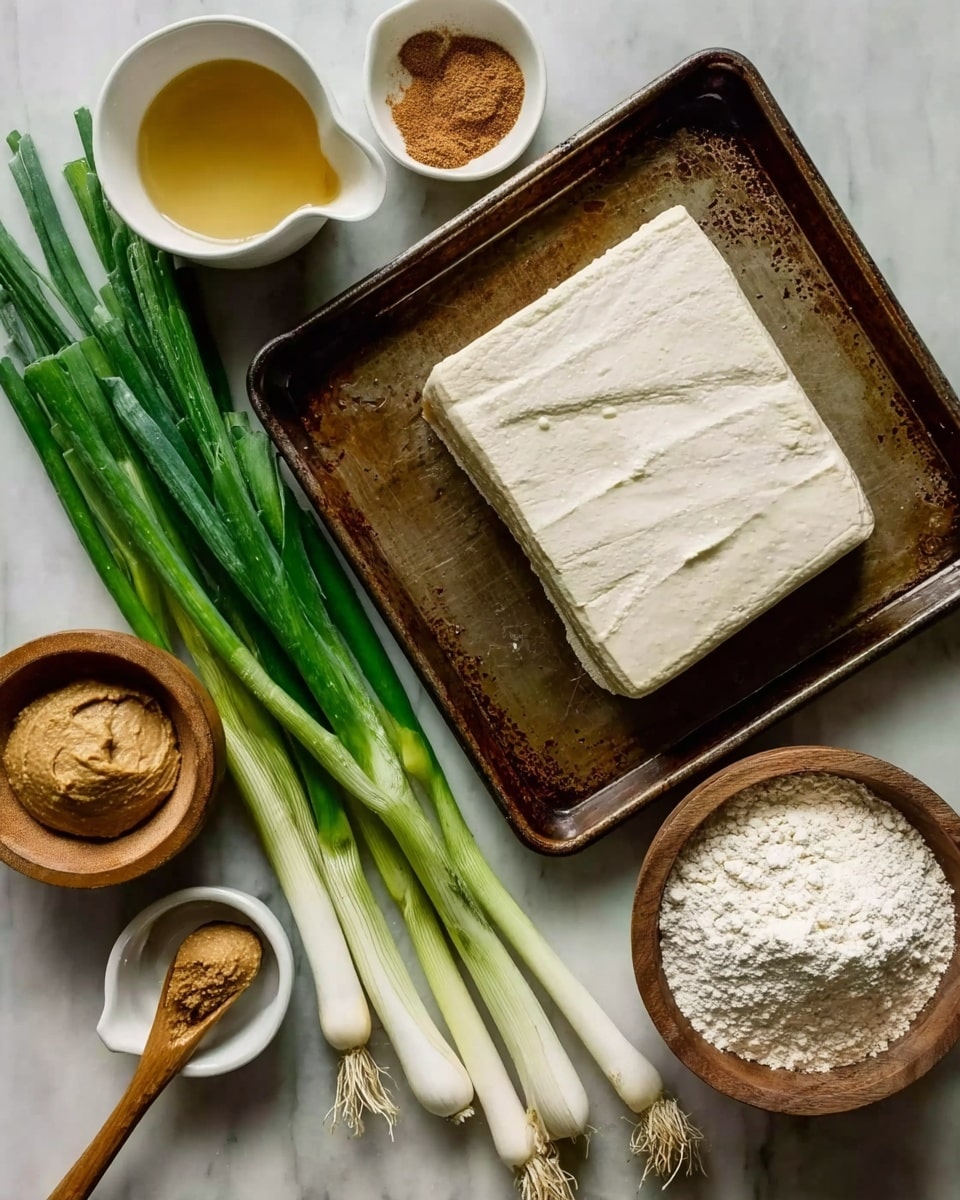 The image shows a baking tray with a block of white tofu on the right side, which has a smooth texture and slight surface wrinkles. To the bottom right of the tray, there is a white bowl filled with flour. Below the tray, a wooden bowl holds a scoop of light brown miso paste with a slightly rough texture. Thick green onions with white bulbs lie horizontally, covering the bottom middle area. Above the green onions, a small white measuring cup contains a golden honey-like liquid with a clear and shiny surface. At the top left, a small white dish holds a heap of brown spice powder next to a wooden spoon. The entire setup is placed on a white marbled surface. Photo taken with an iphone --ar 4:5 --v 7